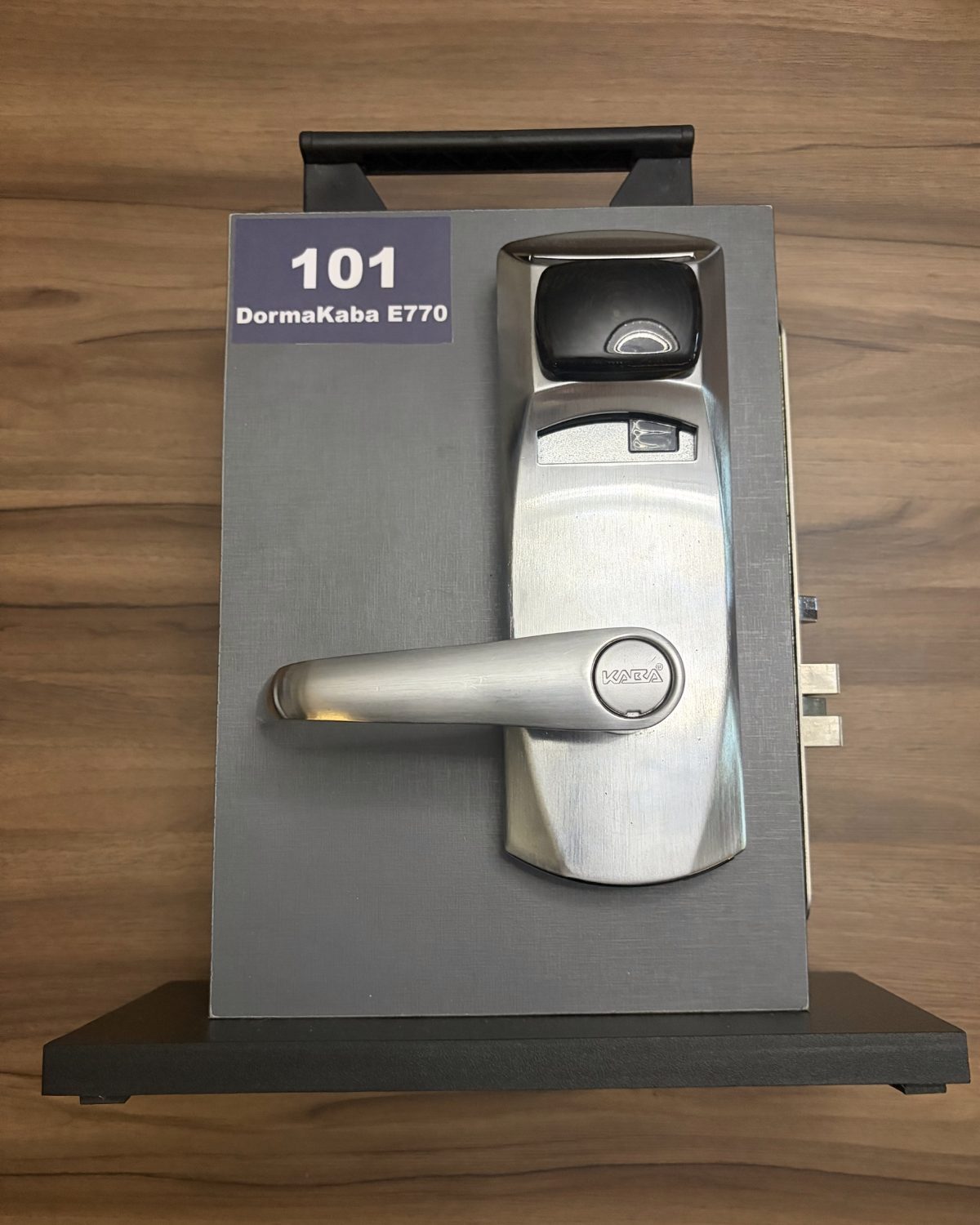 Amostrador 101: fechadura DormaKaba E770 convertida, com leitor RFID por aproximação no topo do espelho.