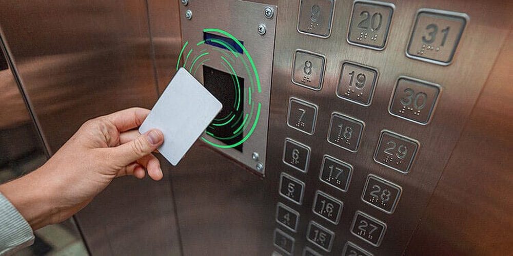 Leitor RFID instalado na botoeira de um elevador: o hóspede aproxima o cartão para liberar o andar.
